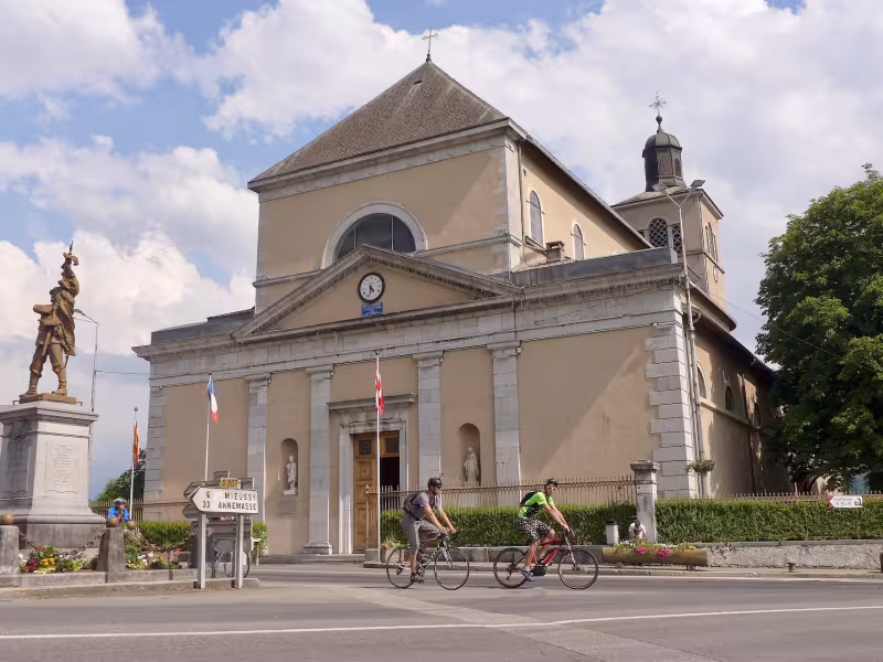 Cyclistes devant l'Église Saint-Jean-Baptiste de Taninges