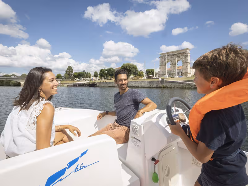 Famille dans e-boat et vue sur Arc de Germanicus
