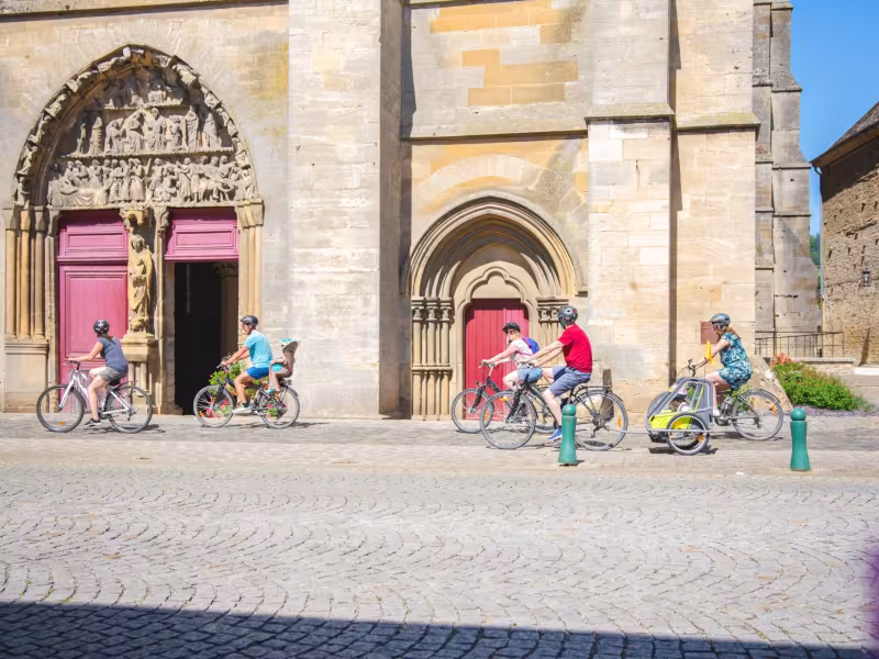 Cyclistes devant l'Abbatiale Notre-Dame de Mouzon