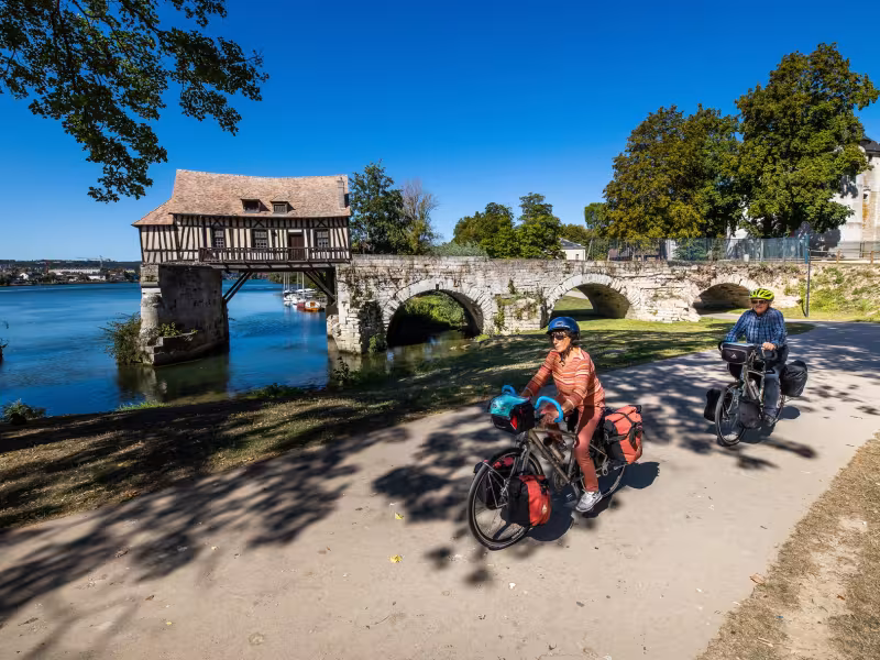 Cyclistes en voyage devant le vieux Moulin à colombage de Vernon