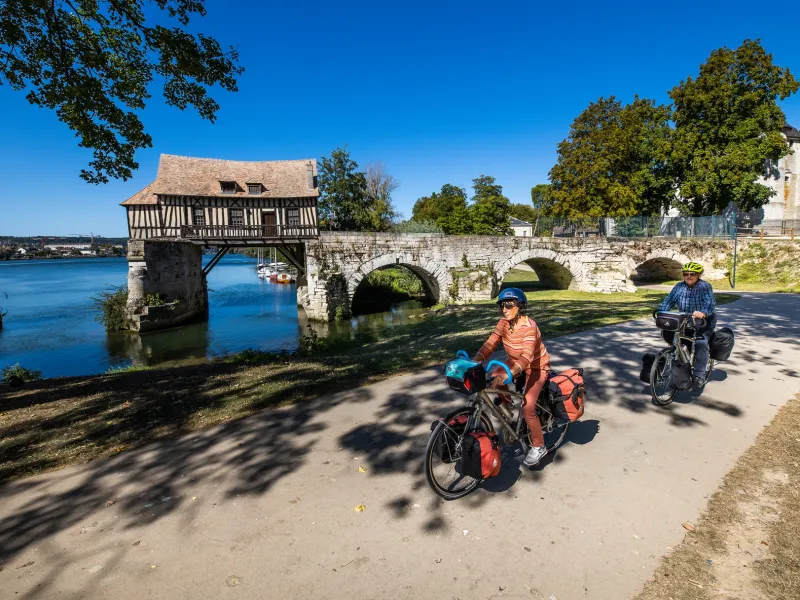 Cyclistes en voyage devant le vieux Moulin à colombage de Vernon