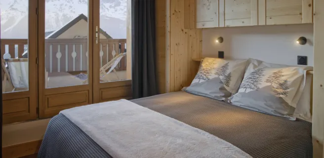 Chambre double avec vue sur Belledonne, balcon avec transats, rangements au-dessus et sur les côté du lit