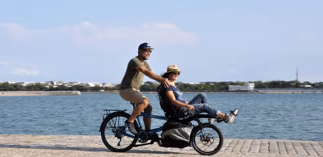 2 personnes sur un tandem en bord de mer